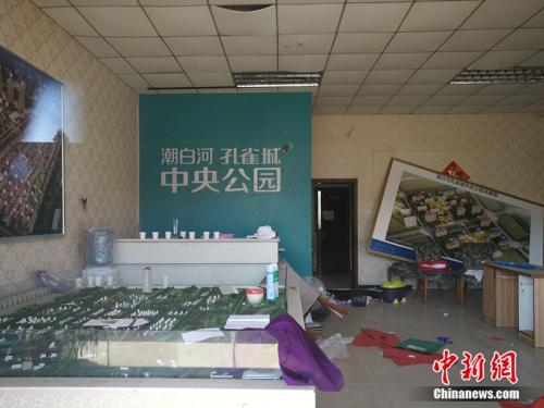 "從燕郊一家已經關門的售樓處門外望進去，地上散落著廢紙、條幅，沙盤上放著落灰的殺蟲劑。<a