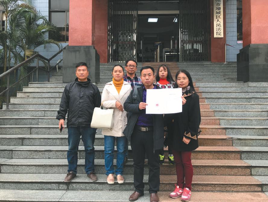 昨日，該案宣判后，幾名被拐幼兒的家長(zhǎng)拿著判決書在法院門口合影。 &nbsp;&nbsp;&nbsp;&nbsp;受訪者供圖