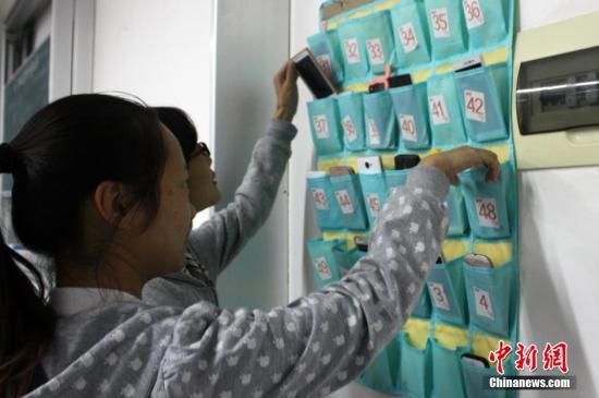  資料圖：江蘇鹽城師范學院城市學院學生上課前，將手機關機或者調成靜音，放在教室門口統一的袋子里，下課后再自行取走。谷華 攝