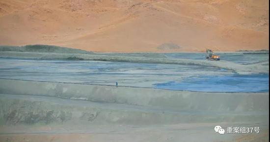 嶸儲莫圪內選礦有限公司的尾礦庫有數個足球場大小，尾礦庫用礦渣堆積而成，中間是排出的黑色污水，挖掘機不斷將尾礦庫壩體筑高。&nbsp;&nbsp;&nbsp; 新京報記者 游天燚 攝