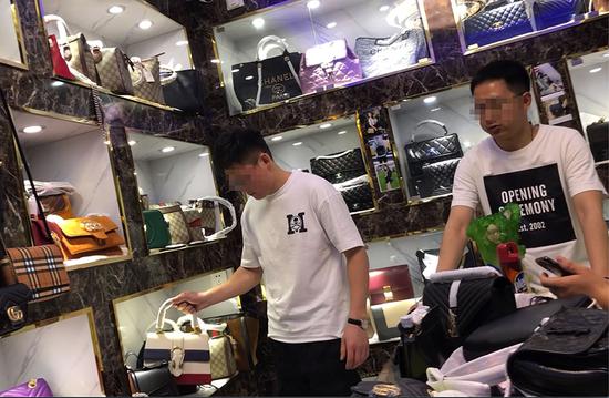 3月15日上午，廣州市白云世界皮具貿易中心旁桂花崗小區。兩位自稱是海淘網店老板的年輕人在售假窩點選購假冒奢侈品。 ????新京報記者 吳江 攝