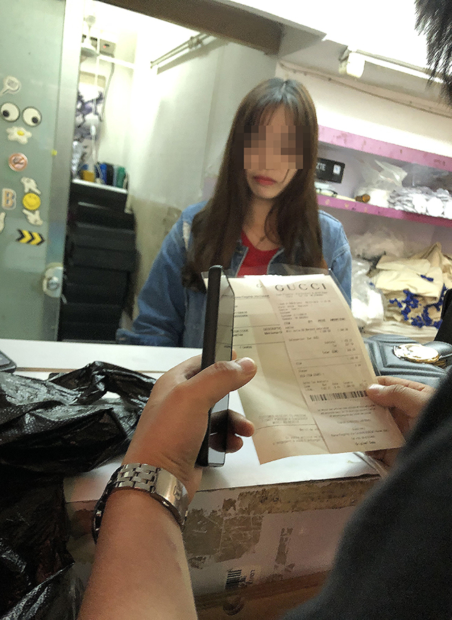 3月16日下午，廣州市白云世界皮具貿(mào)易中心旁桂花崗小區(qū)外商鋪，一處包裝店的工作人員給記者打印出了帶有某品牌標(biāo)志的假冒的奢侈品銷(xiāo)售發(fā)票。 新京報(bào)記者 吳江 攝