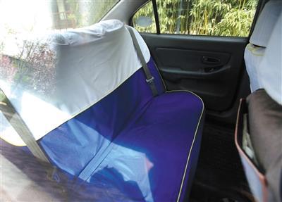 另一輛出租車后排的座套雖然將安全帶露了出來，但鎖扣卻被包在座套下面。