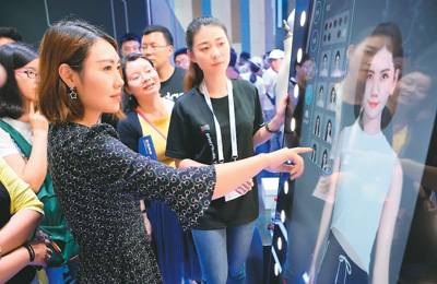 在2018中國國際大數據產業博覽會上，參觀者通過阿里巴巴的虛擬試衣鏡體驗現場試衣。新華社記者 歐東衢攝