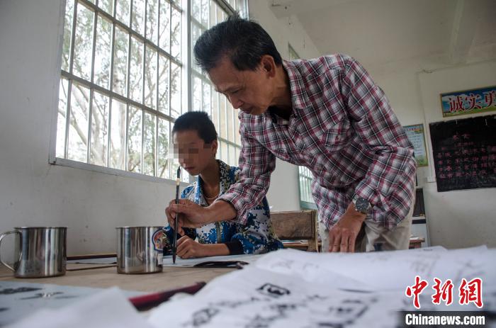 梁志雄教阿興練習毛筆 翟李強 攝